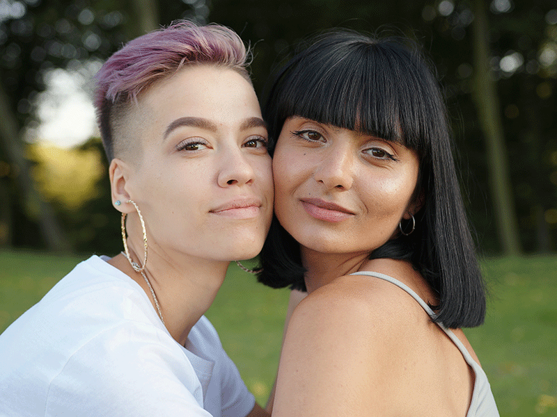 Portrait of happy lesbian LGBT woman in the park looking at the camera