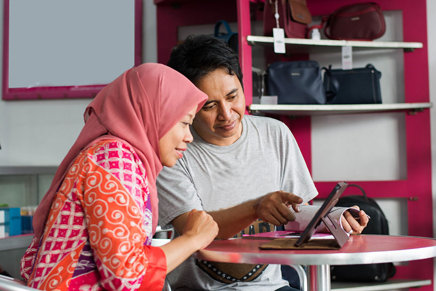 Portrait of Asian muslim middle age husband and wife discuss about business in their store